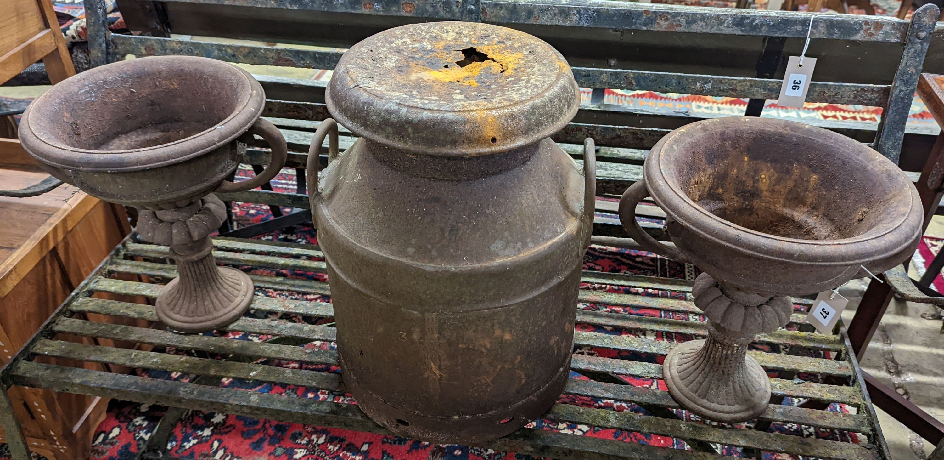 A pair of circular cast iron campana urns, diameter 29cm, height 35cm together with an iron milk churn